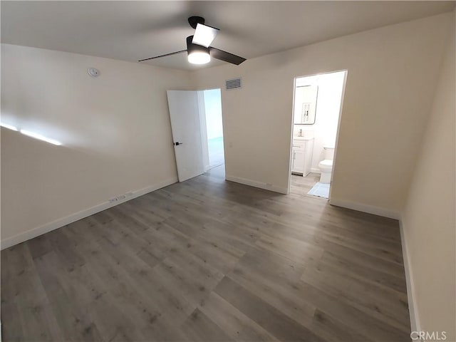 interior space with baseboards, wood finished floors, visible vents, and a ceiling fan