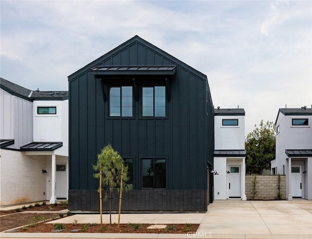 18017 Hazel Ct, Fountain Valley, CA 92708 - modern farmhouse style home featuring a standing seam roof, board and batten siding, and metal roof