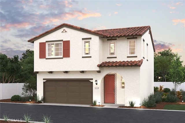 mediterranean / spanish home featuring a tile roof, fence, and stucco siding