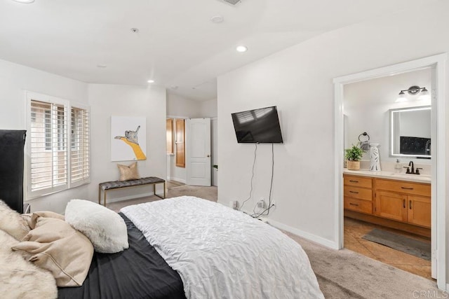 bedroom with recessed lighting, light colored carpet, ensuite bathroom, a sink, and baseboards