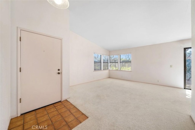 carpeted entrance foyer featuring lofted ceiling and tile patterned flooring