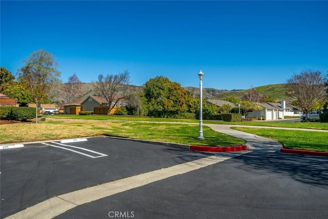 uncovered parking lot featuring a residential view and a mountain view