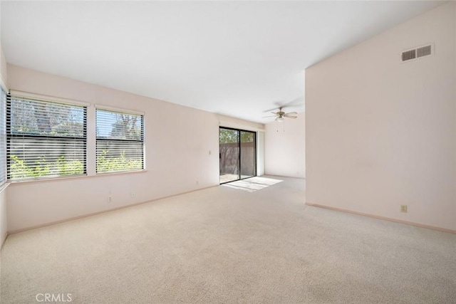 unfurnished room featuring visible vents, ceiling fan, light carpet, and baseboards