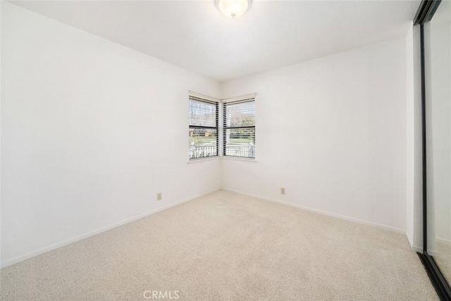 empty room with light carpet and baseboards