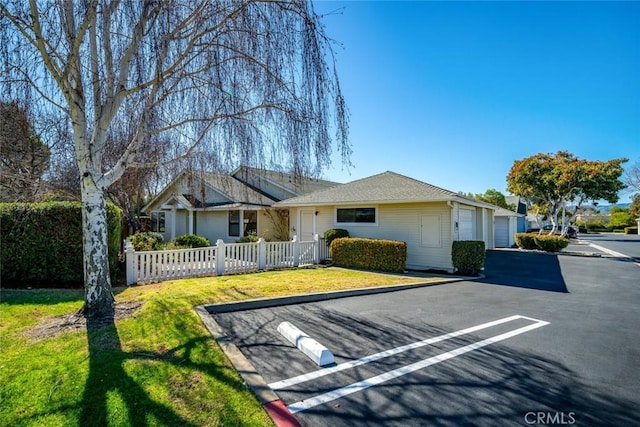 single story home featuring a garage and fence