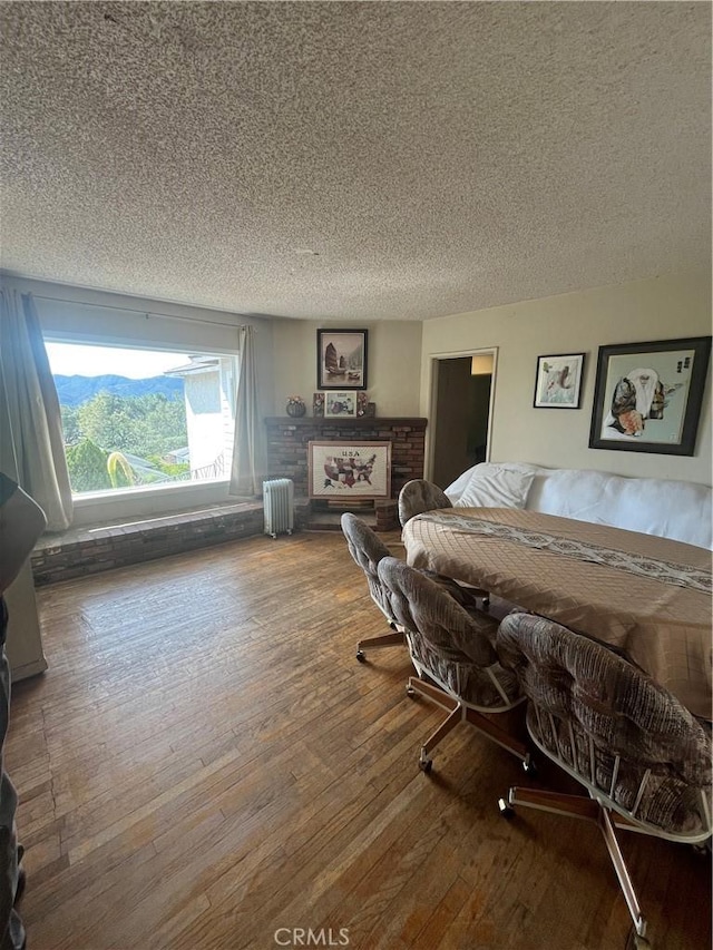 bedroom featuring radiator, a textured ceiling, and wood finished floors