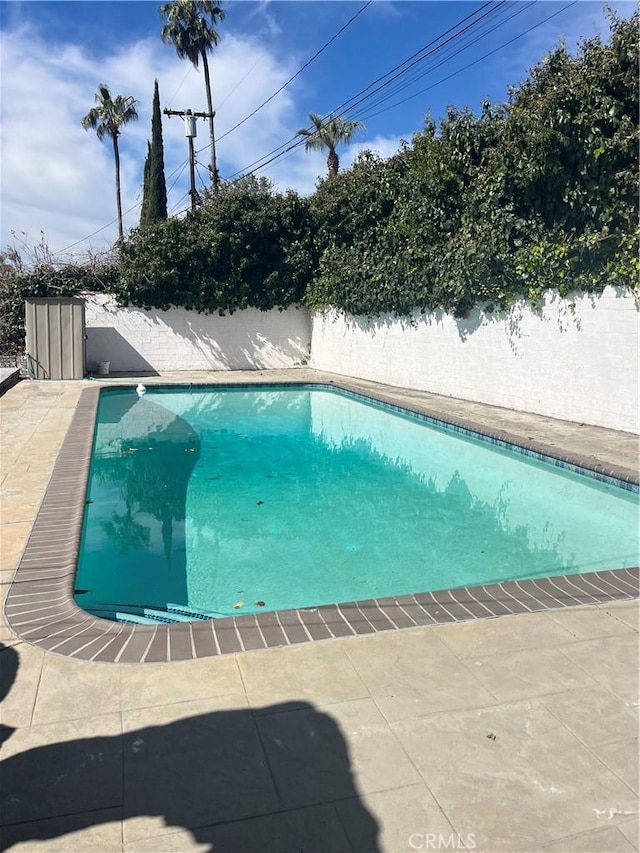 view of pool with a fenced in pool, a patio area, and fence