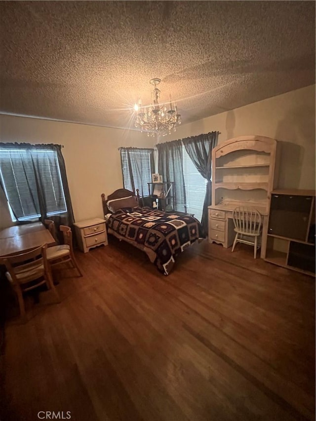 unfurnished bedroom featuring a textured ceiling, a chandelier, and wood finished floors