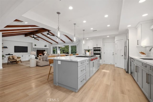 kitchen with pendant lighting, a spacious island, stainless steel appliances, a ceiling fan, and open floor plan