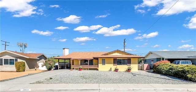 ranch-style house featuring a carport, concrete driveway, and stucco siding