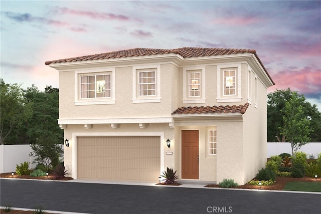 view of front of property with driveway, a tiled roof, fence, and stucco siding