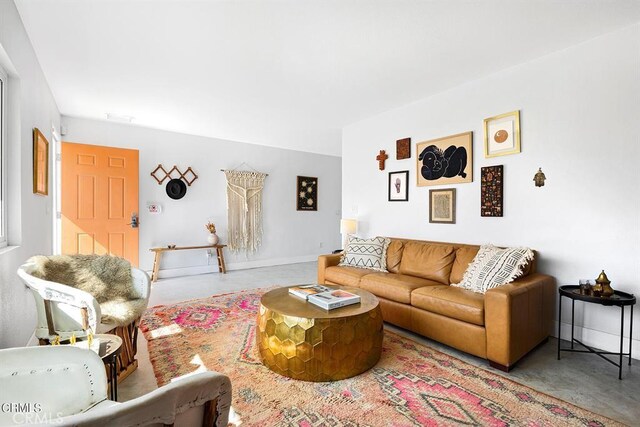 living room featuring finished concrete flooring and baseboards