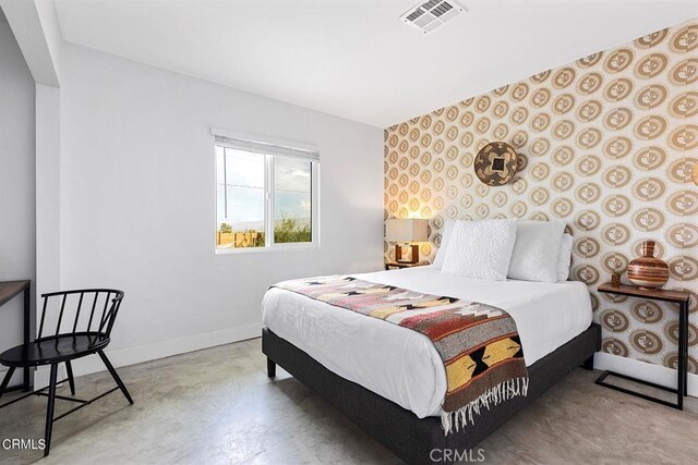 bedroom featuring baseboards, visible vents, and concrete flooring