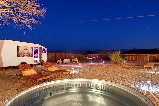 yard at twilight featuring a fenced backyard