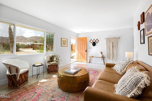 living room with concrete flooring, a mountain view, and baseboards