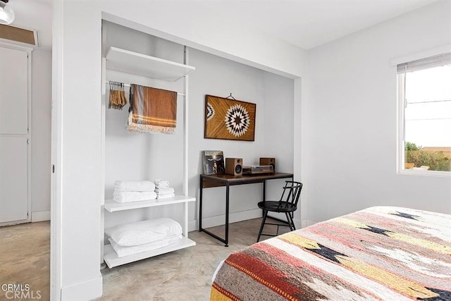 bedroom with a closet and concrete flooring