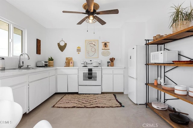 kitchen featuring light countertops, white cabinetry, a sink, white appliances, and concrete floors