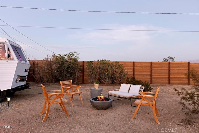 view of patio with an outdoor fire pit and fence