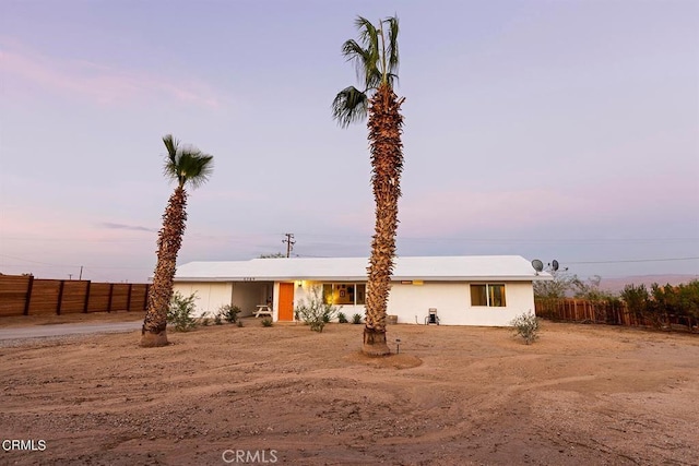 view of front facade featuring fence and stucco siding