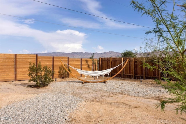 view of yard featuring a fenced backyard and a mountain view