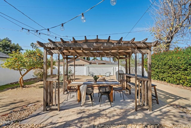 view of patio with outdoor dining space, fence, and a pergola