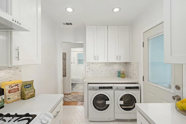 clothes washing area featuring recessed lighting, visible vents, independent washer and dryer, and cabinet space