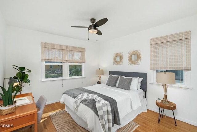 bedroom featuring a ceiling fan, baseboards, and wood finished floors