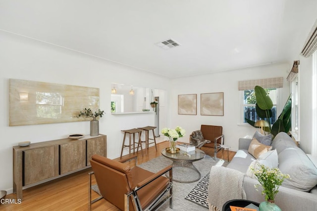 living area featuring light wood-style floors and visible vents