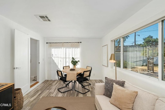 dining space featuring light wood-style flooring and visible vents