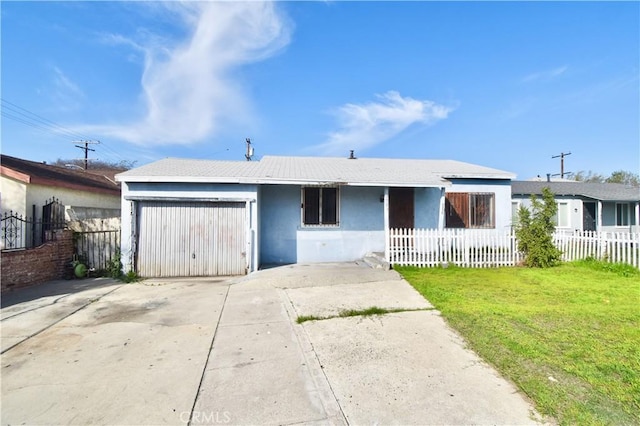 view of front of home with a fenced front yard, driveway, and an attached garage