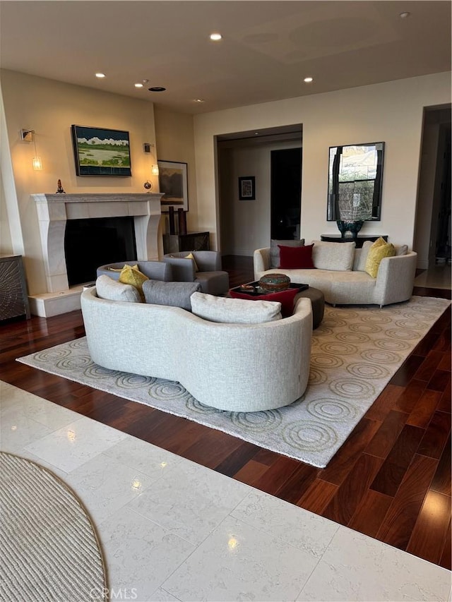 living area featuring a high end fireplace, wood finished floors, and recessed lighting