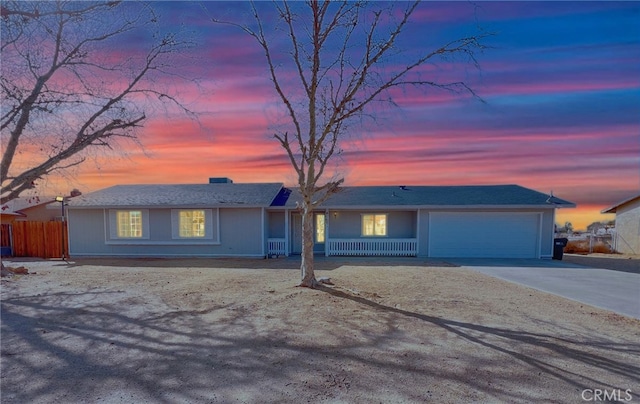 ranch-style home with a garage, driveway, and fence