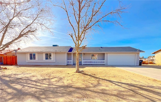 ranch-style home with a garage, driveway, and fence