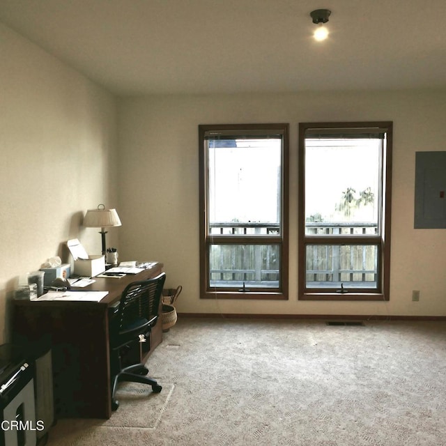 office with light carpet, visible vents, electric panel, and baseboards