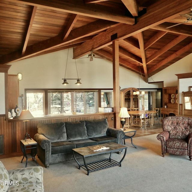 carpeted living area featuring a chandelier, wooden ceiling, wainscoting, and beamed ceiling