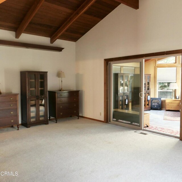 interior space with light carpet, visible vents, wood ceiling, high vaulted ceiling, and beam ceiling