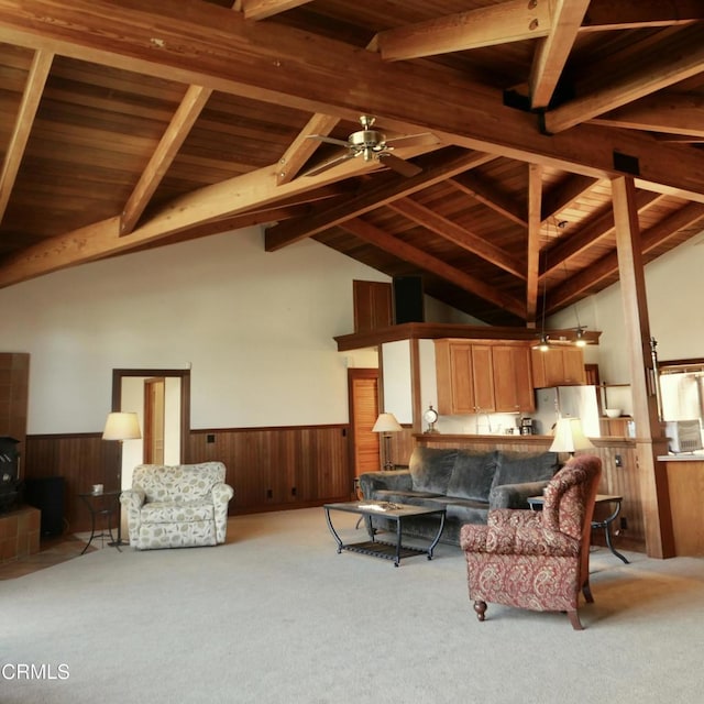 carpeted living area with lofted ceiling with beams, wainscoting, wooden ceiling, and wooden walls