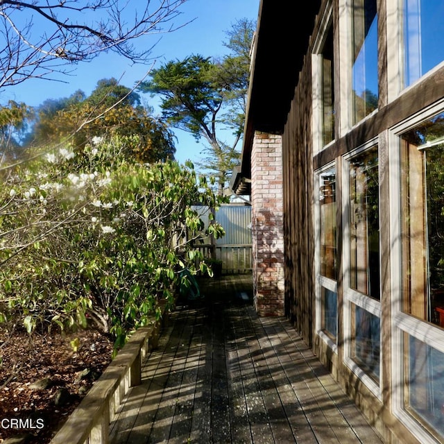 view of side of home with a wooden deck and brick siding