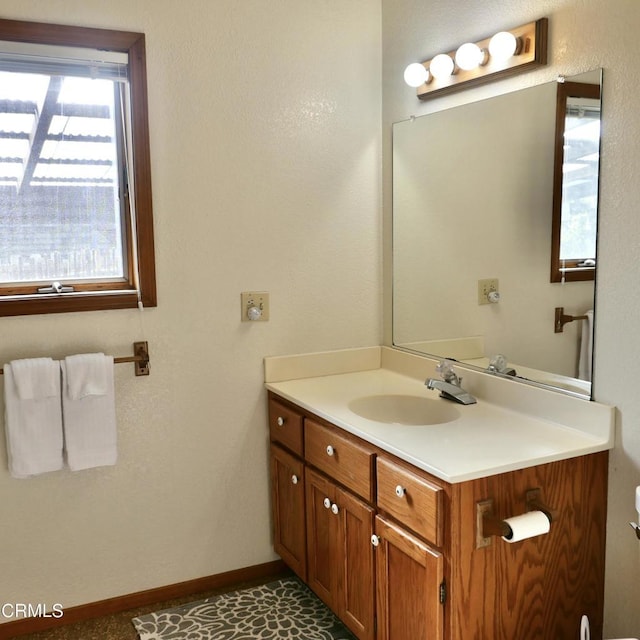 half bathroom featuring vanity and baseboards