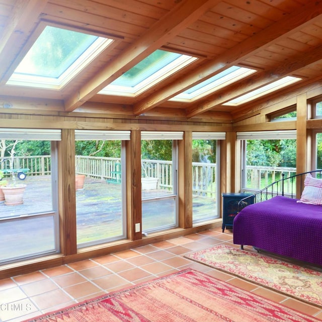 bedroom featuring vaulted ceiling with skylight, wooden ceiling, light tile patterned flooring, and multiple windows