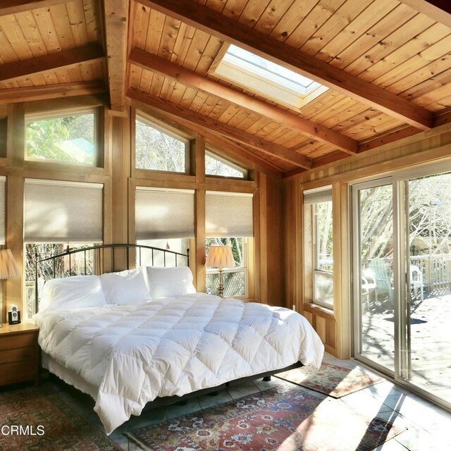 bedroom with access to outside, lofted ceiling with skylight, multiple windows, and wooden ceiling