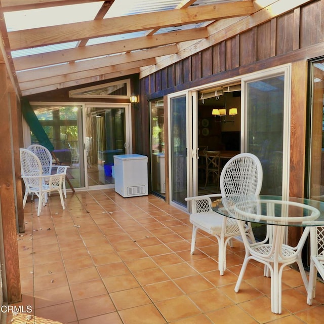 sunroom / solarium featuring lofted ceiling with beams