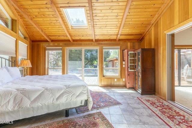 bedroom with light tile patterned floors, access to exterior, wooden ceiling, wooden walls, and lofted ceiling with skylight