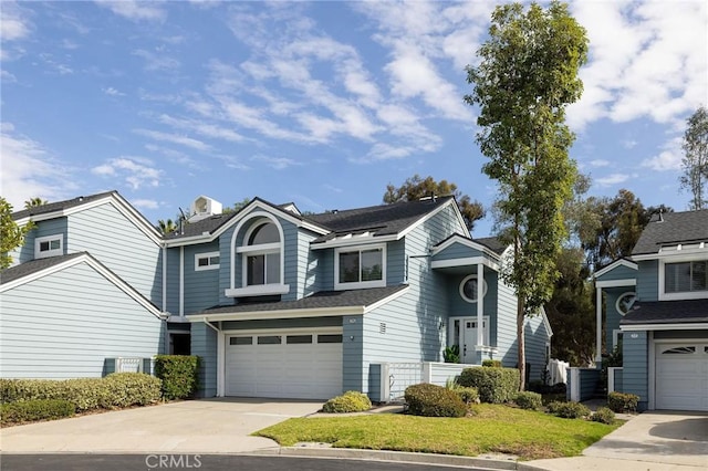 traditional home featuring driveway, central air condition unit, a garage, and a front lawn