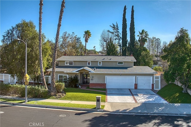 traditional home with concrete driveway, a front lawn, brick siding, and stucco siding