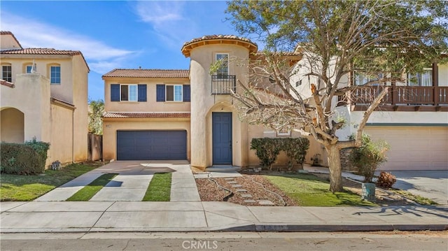 mediterranean / spanish-style home with concrete driveway, a balcony, a tile roof, an attached garage, and stucco siding