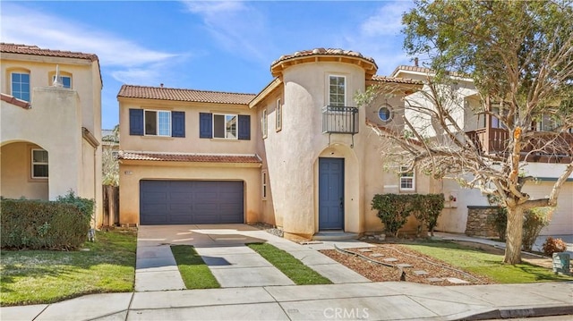 mediterranean / spanish-style home with a tile roof, driveway, an attached garage, and stucco siding