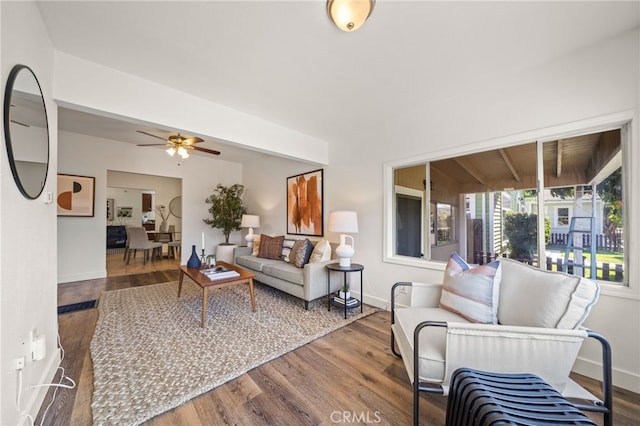 living area with ceiling fan, baseboards, and wood finished floors