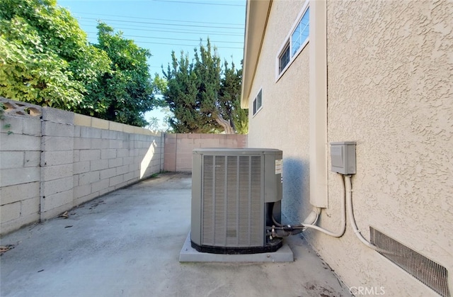 details with central AC, a fenced backyard, and stucco siding