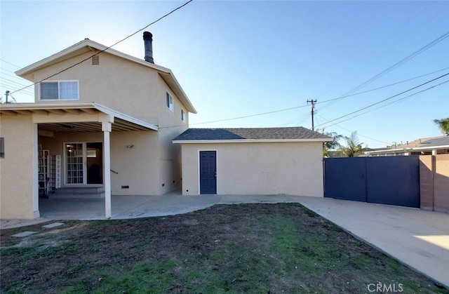 rear view of property featuring stucco siding, fence, and a patio
